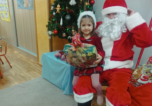 08. Dziewczynka siedzi na kolanach Świętego Mikołaja.