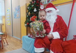 09. Dziewczynka siedzi na kolanach Świętego Mikołaja.