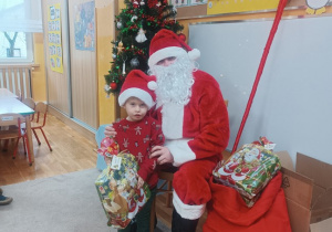 12. Chłopiec stoi obok Świętego Mikołaja.