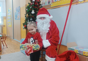 20. Dziewczynka stoi obok Mikołaja.