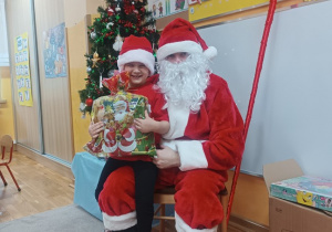 22. Chłopiec siedzi na kolanach Świętego Mikołaja.