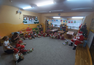 24. Dzieci dziękują za prezenty Mikołajowi.