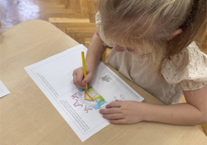 Dziewczynka koloruje obrazek.