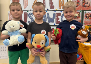 Chłopcy pokazują swoje misie.