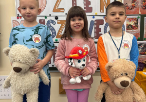 Dzieci trzymają w rączkach ulubionego misia.