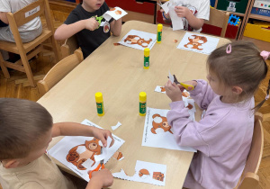 Dzieci wycinają elementy misia.