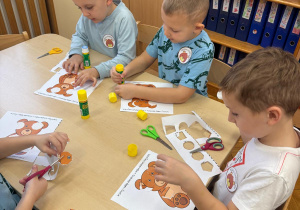 Chłopcy wycinają elementy misia.