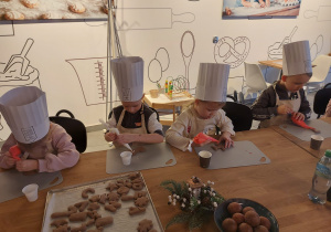 Dzieci lukrują pierniczki.