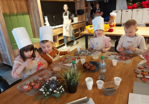 Dziec i dekorują pierniki lukrem i posypkami.