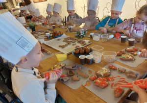 Dzieci lukrują ciasteczka.