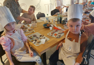 Chłopiec i dziewczynka siedzą przy skończonych ciasteczkach.