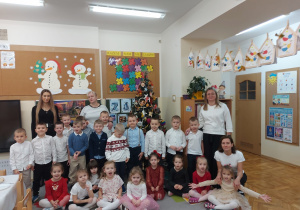 Dzieci pozują do wspólnego zdjęcia z paniami przy choince.