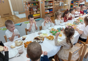 Dzieci spożywają wigilijne potrawy.
