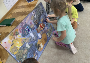 Dziewczynka przykleja do plakatu kolejnego Czuciaka - Bojka.