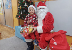 Uśmiechnięty chłopiec z Mikołajem.