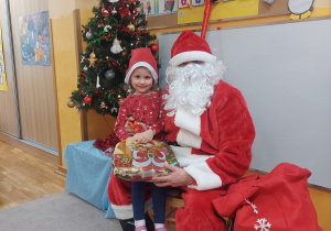 Dziewczynka z Mikołajem i prezentem.