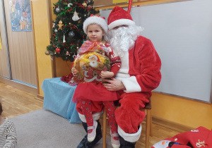 Dziewczynka z Mikołajem i prezentem.