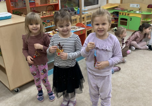 Dziewczynki będą wieszać ozdoby na choinkę.