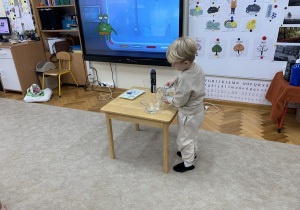 Chłopiec wlewa wodę do miski.