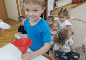 Chłopiec będzie sypał do balona ryż.