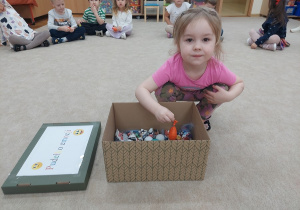 Dziewczynka chowa gniotka do pudełka emocji.