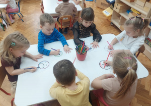 Dzieci kolorują emotki, które później wytną nożyczkami.