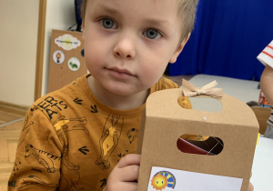 Chłopiec prezentuje zrobiony upominek.