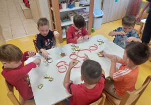 Chłopcy pakują pierniczki do torebek.