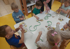 Przedszkolaki pakują pierniczki przywiezione ze spotkania z Woliczankami.