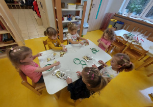 Dziewczynki wkładają pierniczki do woreczków.