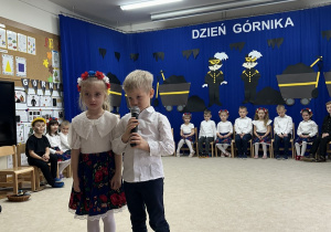 Dziewczynka i chłopiec witają zgromadzonych.