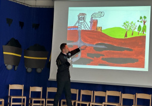 Górnik pokazuje na ekranie skąd wydobywa się węgiel.
