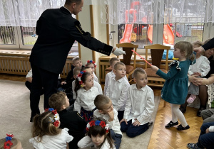 Pan wręcza dziewczynce upominek.