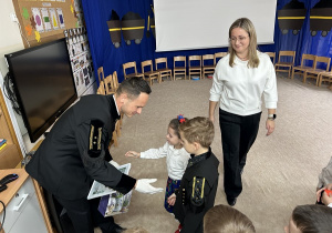 Dzieci wręczają górnikowi podziękowania i upominek.