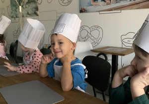 Chłopcy w czapeczkach kucharskich.