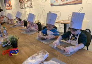 Kropelki rozwałkowują ciasto do wykrawania pierniczków.