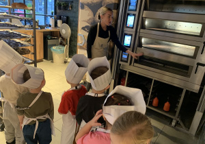 Pani pokazuje dzieciom piec do którego trafią pierniki.