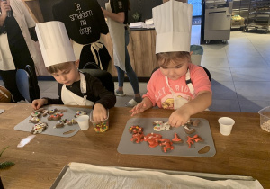 Dziewczynka sypie posypkę na lukier.