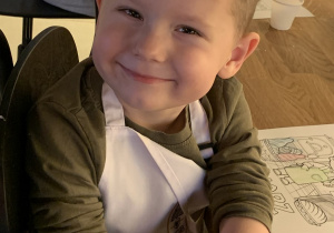 Chłopiec pokazuje odbitą pieczątkę piekarni na swojej ręcę.