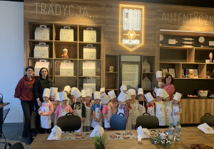 Zdjęcie na tle szyldu piekarni.