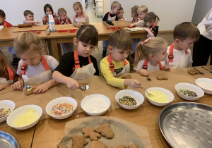 Grupka dzieci rozpoczyna dekorowanie pierników.