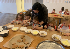 Dzieci nakładają lukier na pierniczki.