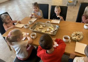 Wspólny poczęstunek z ciasteczkiem i herbatką.