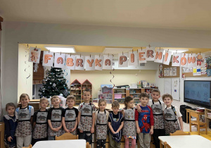 Dzieci ubrane w fartuszki pozują do zdjęcia.