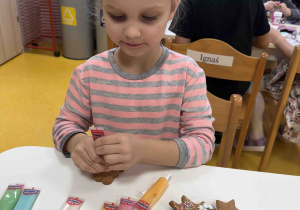 Dziewczynka ozdabia swoje pierniczki.