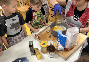 Pani wlewa miód ze słoika.