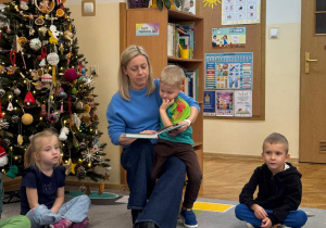 Mama czyta bajkę z Piotrusiem na kolanach.