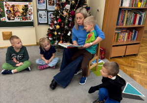 Dzieci słuchają bajki czytanej przez mamę.