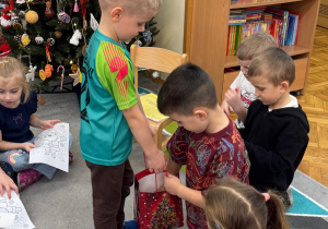 Chłopiec częstuje dzieci cukierkami.