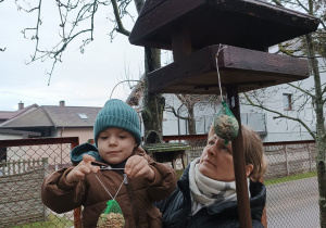12 Chłopiec zawiesza przysmaki dla ptaszków